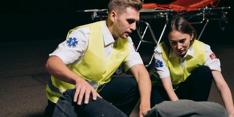 Profissionais dando primeiros socorros em pessoa acidentada.