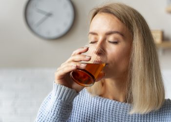 mulher bebendo kombucha vista lateral scaled