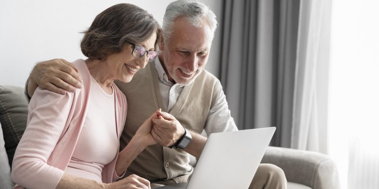 casal senior em plano medio com laptop scaled