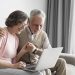casal senior em plano medio com laptop scaled