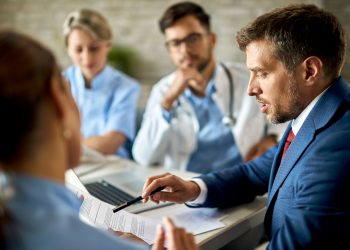 mid adult businessman healthcare workers analyzing documents during meeting office scaled