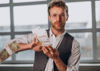 homem com notas isoladas em estudio scaled