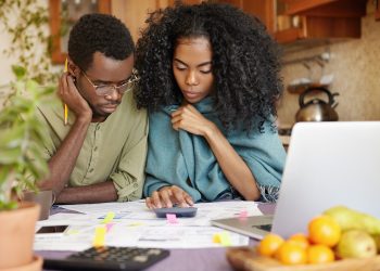 jovem casal afro americano infeliz e deprimido calculando o orcamento familiar scaled