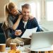 happy couple analyzing their home budget while paying bill computer scaled