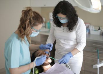Paciente em um atendimento odontológico com duas dentistas.