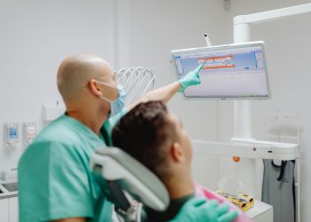 Doutor mostrando exame odontológico para paciente.