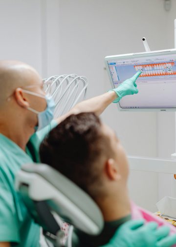 Doutor mostrando exame odontológico para paciente.