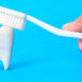 Hipoplasia de esmalte - Dente e escova de dente branca no fundo azul
