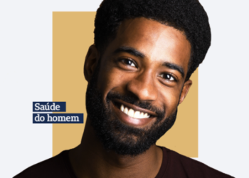 homem negro sorrindo de costas para um fundo laranja com a frase saúde do homem em uma caixa azul