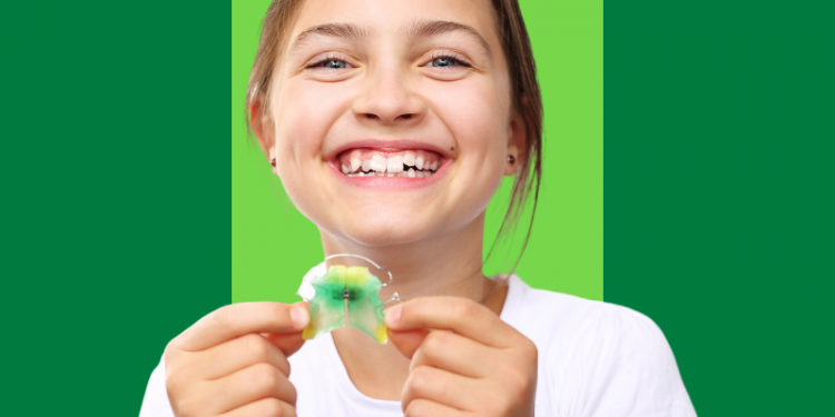 criança, menina, sorrindo enquanto segura um aparelho móvel nas mãos, capa do conteúdo sobre dentes apinhados