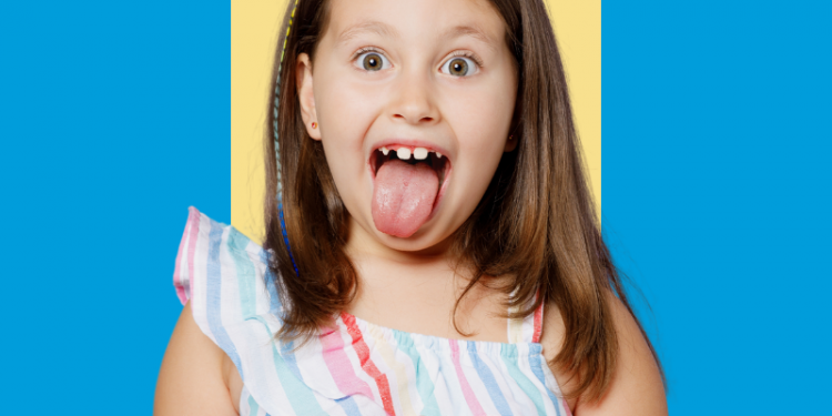 menina, criança, sorrindo e com a língua para fora, faltando alguns dentes de leite e com alguns separados, capa do conteúdo sobre frenectomia