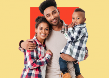 Homem sorrindo abraçado a sua esposa e segurando o filho, criança, no colo. Capa do conteúdo sobre o que é seguro de vida familiar