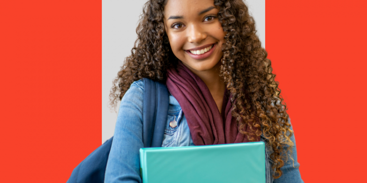 Mulher, estagiária, sorrindo enquanto entende o que é o seguro de vida para estagiários