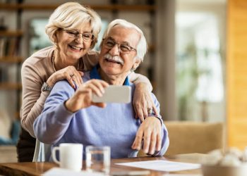 A imagem mostra dois idosos se abraçando.