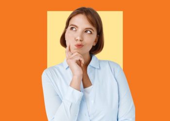 Uma mulher está com a mão no queixo, pensando em algo.
