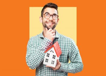 Um homem com uma casa de brinquedo em suas mãos