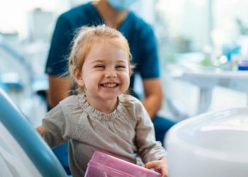 Uma menina sorrindo em um consultório odontológico