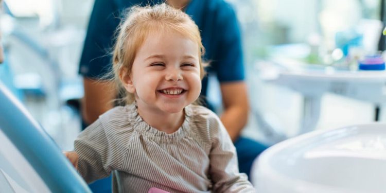 Uma menina sorrindo em um consultório odontológico