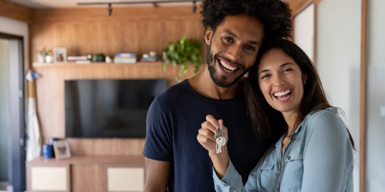 Um casal feliz em sua casa, segurando uma chave