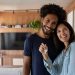 Um casal feliz em sua casa, segurando uma chave
