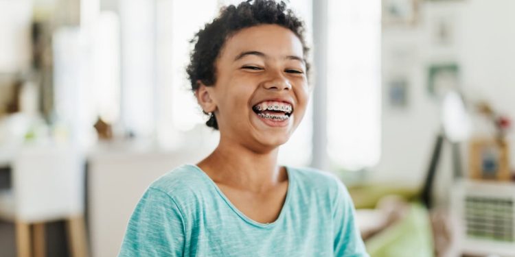 Uma criança sorrindo mostrando seu aparelho