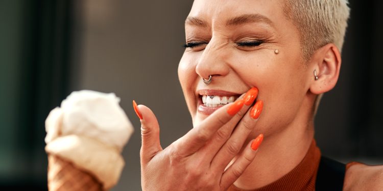 Pessoa sorrindo tomando sorvete.