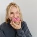 Mulher loira mordendo cupcake rosa