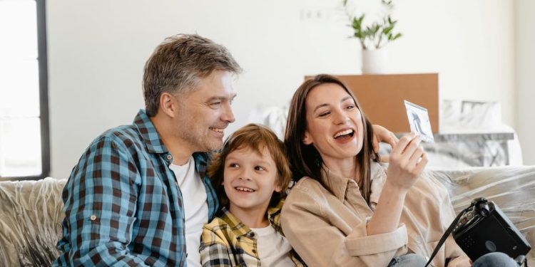 Família, pai filho e mãe, feliz se divertindo no sofá.