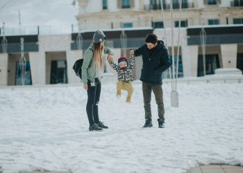 Família de mãe, filho e pai felizes na neve.