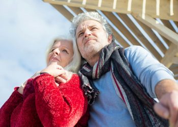 Casal de idosos se abraçando tranquilos.