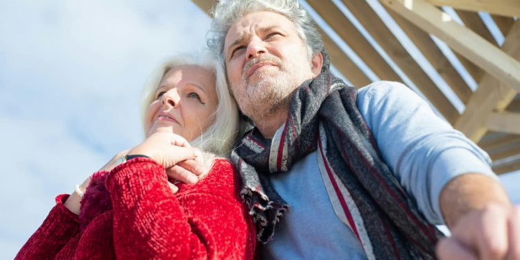Casal de idosos se abraçando tranquilos.