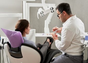 Paciente e dentista em consultório odontológico.